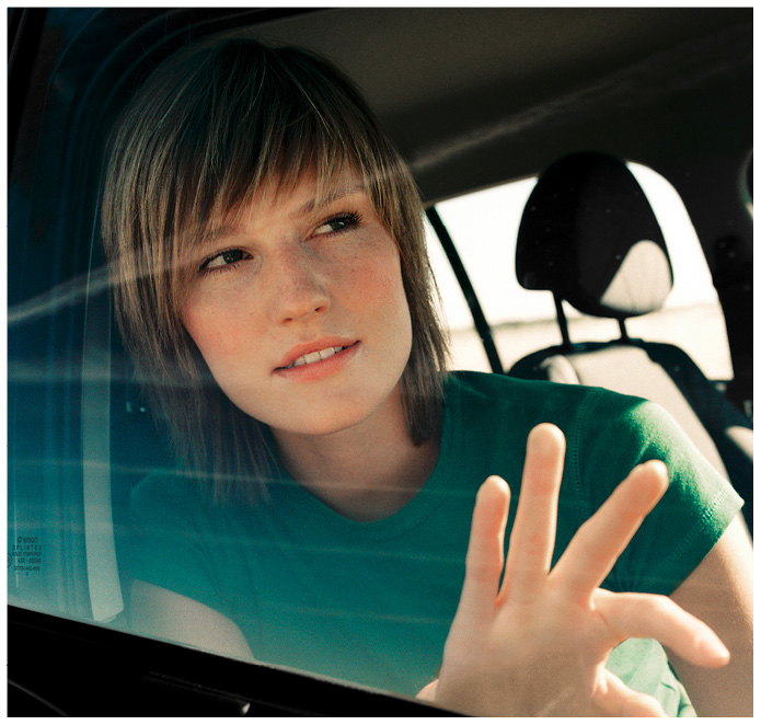 Junge Frau schaut durch das Fenster eines Autos