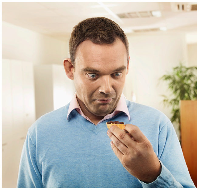 Mann schaut erstaunt mit grossen Augen auf sein Brot