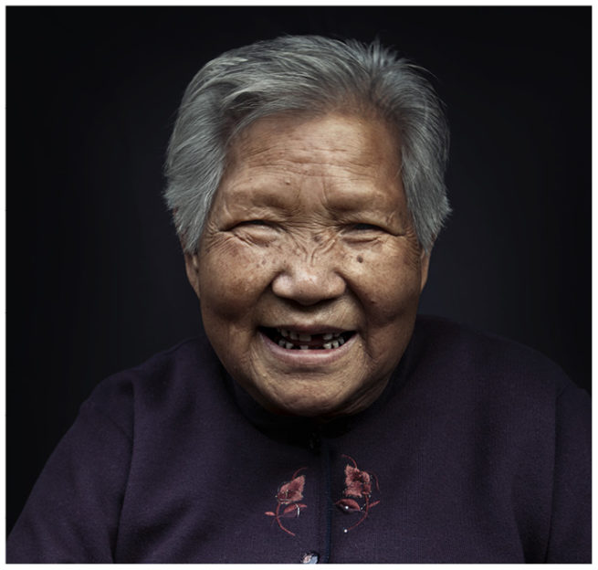 Portrait einer alten Chinesin vor schwarzem Hintergrund