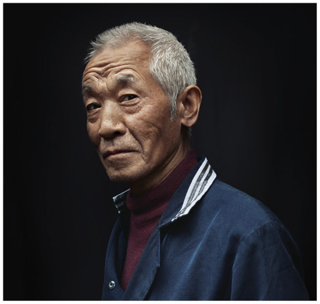 Portrait einer alten Chinesin vor schwarzem Hintergrund