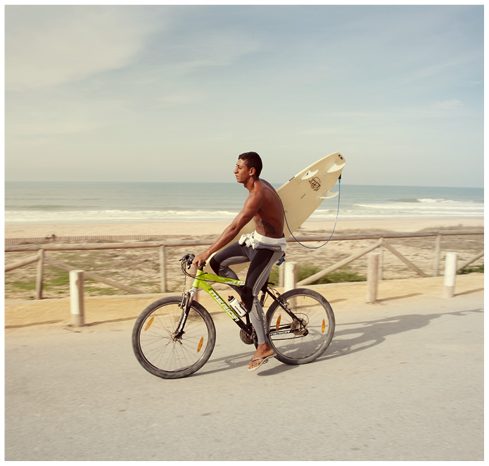 Radfahrer mit Surfboard am Strand von Conil