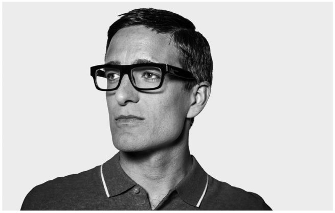 Portrait von einem Mann mit schwarzer Hornbrille im Studio vor weissem Hintergrund