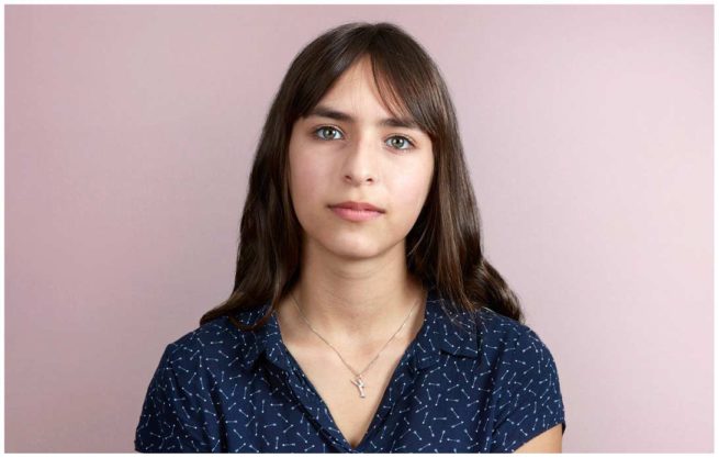 Portrait von einem Teenagermädchen vor rosafarbenem Hintergrund